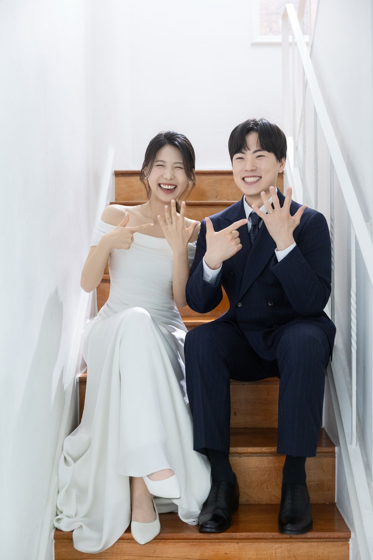 반지를 낀 손을 가리키며 웃고 있는 신랑 유호일과 신부 임규리